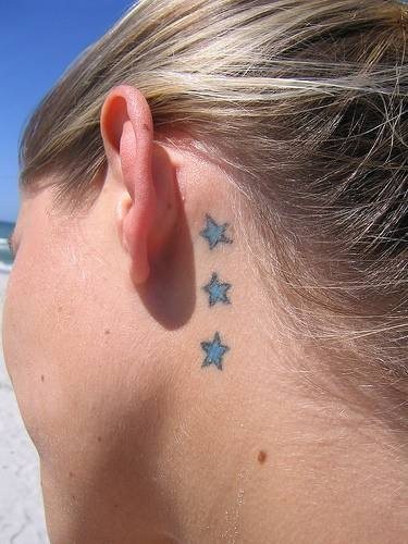 Image of a tattoo of three blue stars behind the ear