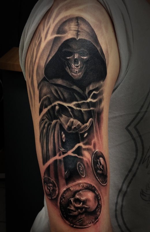 Tattoo of the representation of death tattooed on the arm, in black, how could it be otherwise and under this representation are some coins that seem to be flying and that have been minted with a lateral skull, emulating what is the own death who is throwing coins