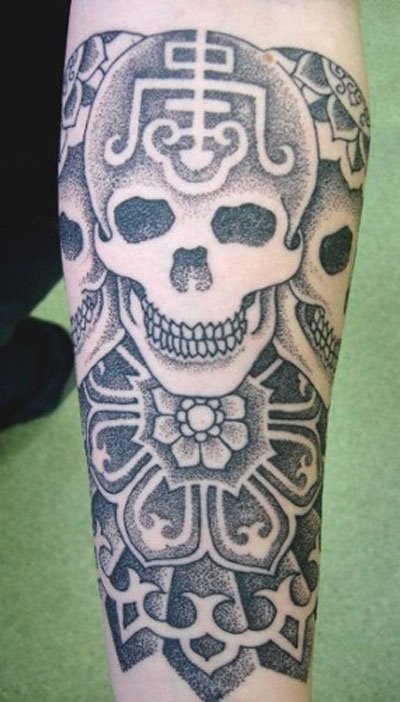 Very original skull tattoo, thanks to the other drawings that complete the skull, which if we look at are three exactly the same skulls but with different drawing on the skull, a good job that we like a lot, to find originality in the design of skulls In addition, the floral motifs with which the tattoo ends at the end gives it a super nice look