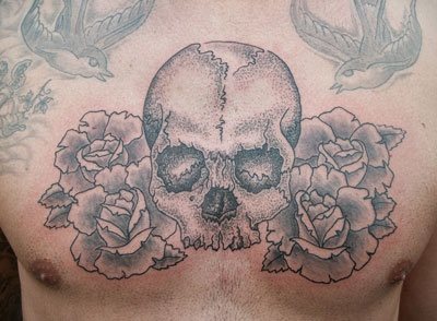 A simpler design of a skull surrounded by large roses and with two swallows flying around