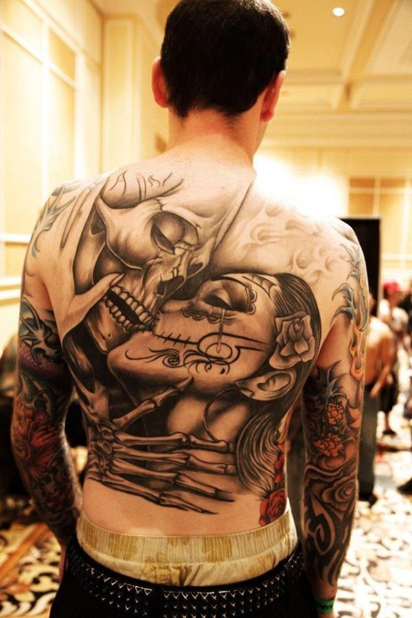 Nice tattoo that represents the kiss between a skull and a woman also characterized as a skull