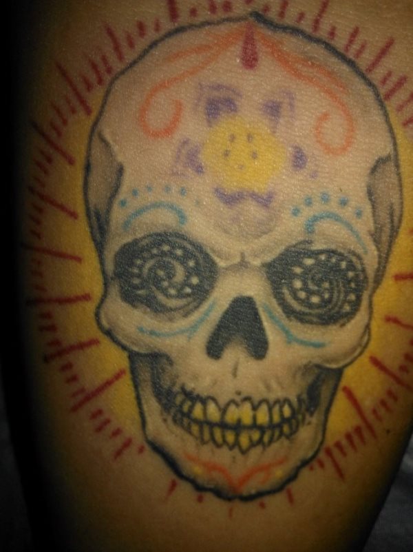 Tattoo of a colorful Mexican skull, in which perhaps reviewing the colored strokes and increasing the thickness of these would achieve a better result, it seems a tattoo that the passage of time on the skin has made of theirs, so a good review would devour the touch of genius that this tattoo should have had when it was drawn