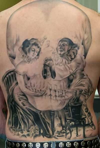 Espectacular tatuaje del que no podemos disimular que nos encante, pero es que no podemos negar que estamos ante un dibujo digno de obra de arte, para el que el dibujo de dos payasos que toman un vino sentado mientras juegan, dan como resultado la silueta de una calavera, sencillamente genial