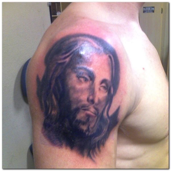 Tattoo on the arm of the countenance of Jesus Christ with great long hair and beards and a very deep look, a tattoo widely used by all those religious people who want to have the Lord close to help them every day