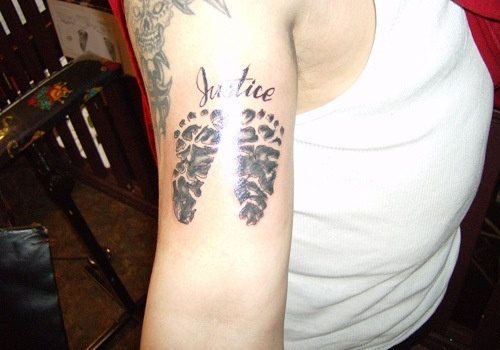 Two feet design of another baby accompanied by the word justice, which in Spanish means justice