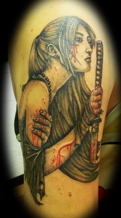 Tattoo of a girl who carries a samurai sword with traces of blood on her hands, arms and face