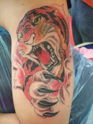 Tattoo of a fierce tiger showing its claws