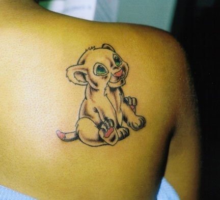 Tattoo of a smiling lion cub on the back of this girl, the tattoo has been added green eyes and the palms of the legs, tail and nose in pink, a very simple design that make it a very tattoo sympathetic