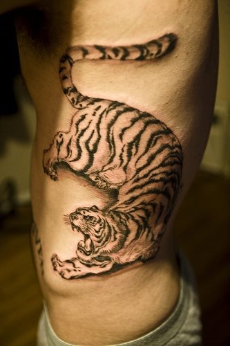 A fierce tiger tattooed on the side