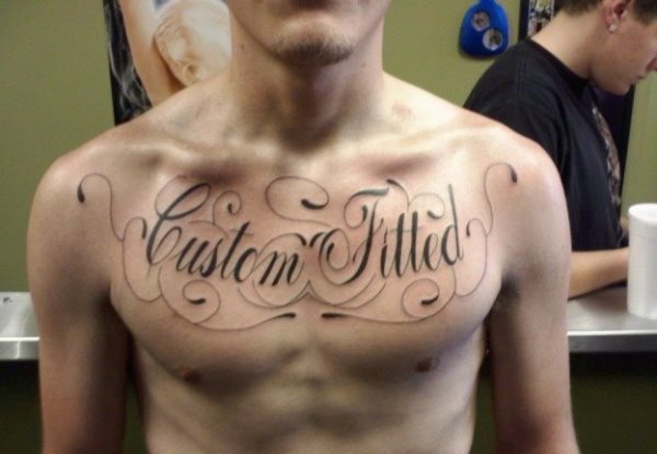 Tattoo that occupies the entire chest with the words custom filled or custom fitted, for which very thin and simple strokes have been used, as well as the borders that have been tattooed around the phrase