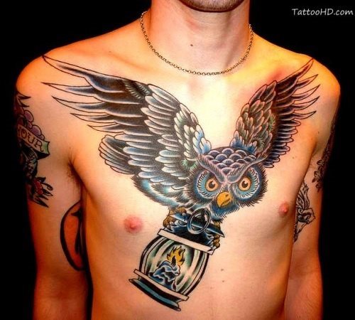 Tattoo of a blue and black owl that carries a candlestick with a candle inside its claws, the truth is that it is a very beautiful tattoo that has caught our attention and that feels great for any part of the body, although for this size needed something big as is the chest